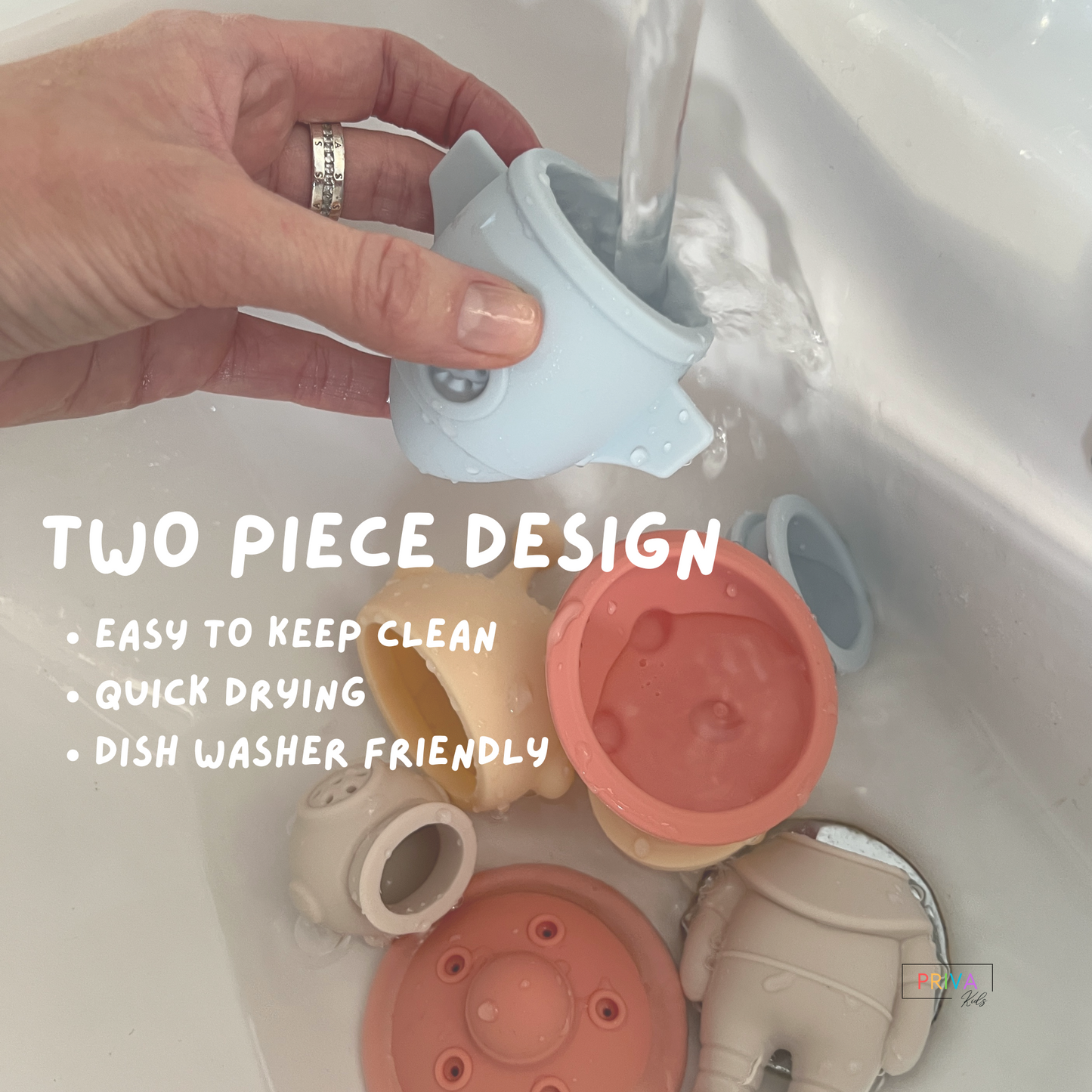 Hand rinsing two-piece silicone rocket bath toy in sink with other pastel space-themed bath toys; features easy-to-clean, quick-drying, dishwasher-safe design