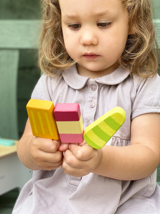 Child holding colorful ice cream toy blocks