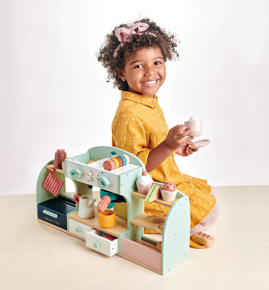 Child playing with a toy kitchen set on a white background