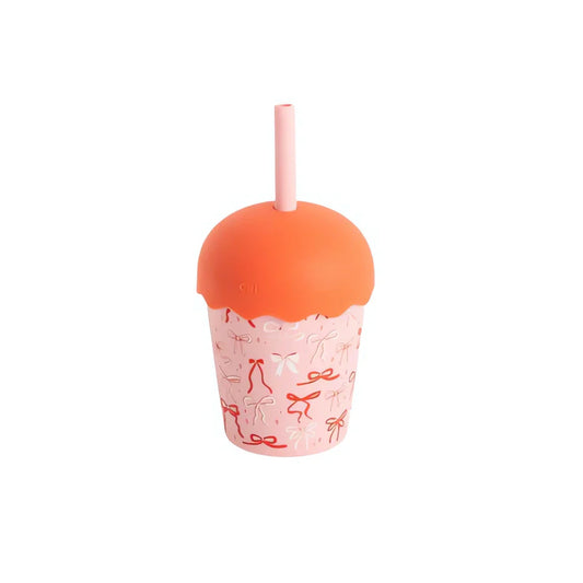 Pink cup with orange lid and straw on a white background